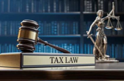 Tax Law: Judge's Gavel as a symbol of legal system, Themis is the goddess of justice and wooden stand with text word on the background of books.